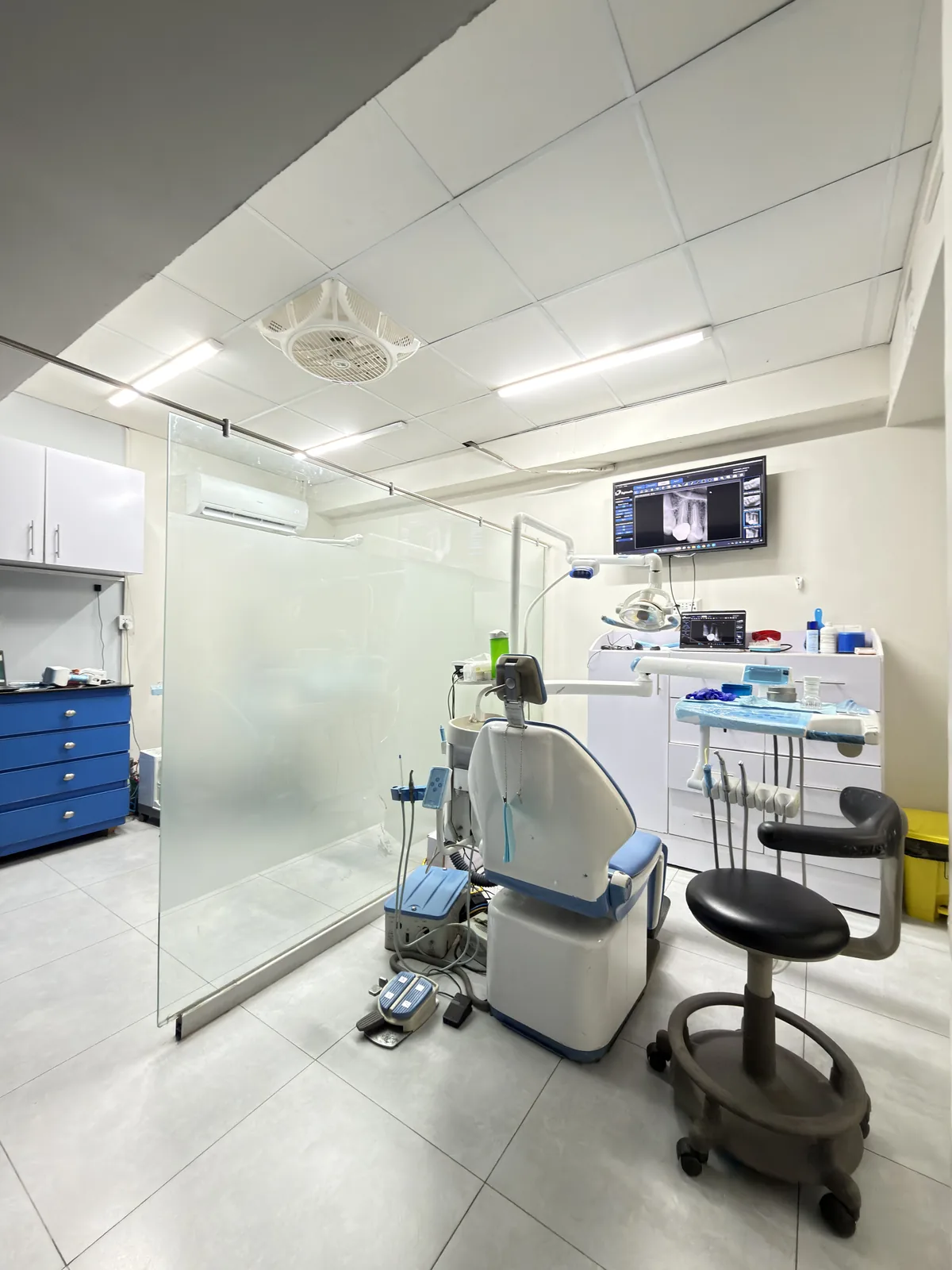 Prepared dental treatment room with dental chair and cabinetry at Dr Hashim and Associates